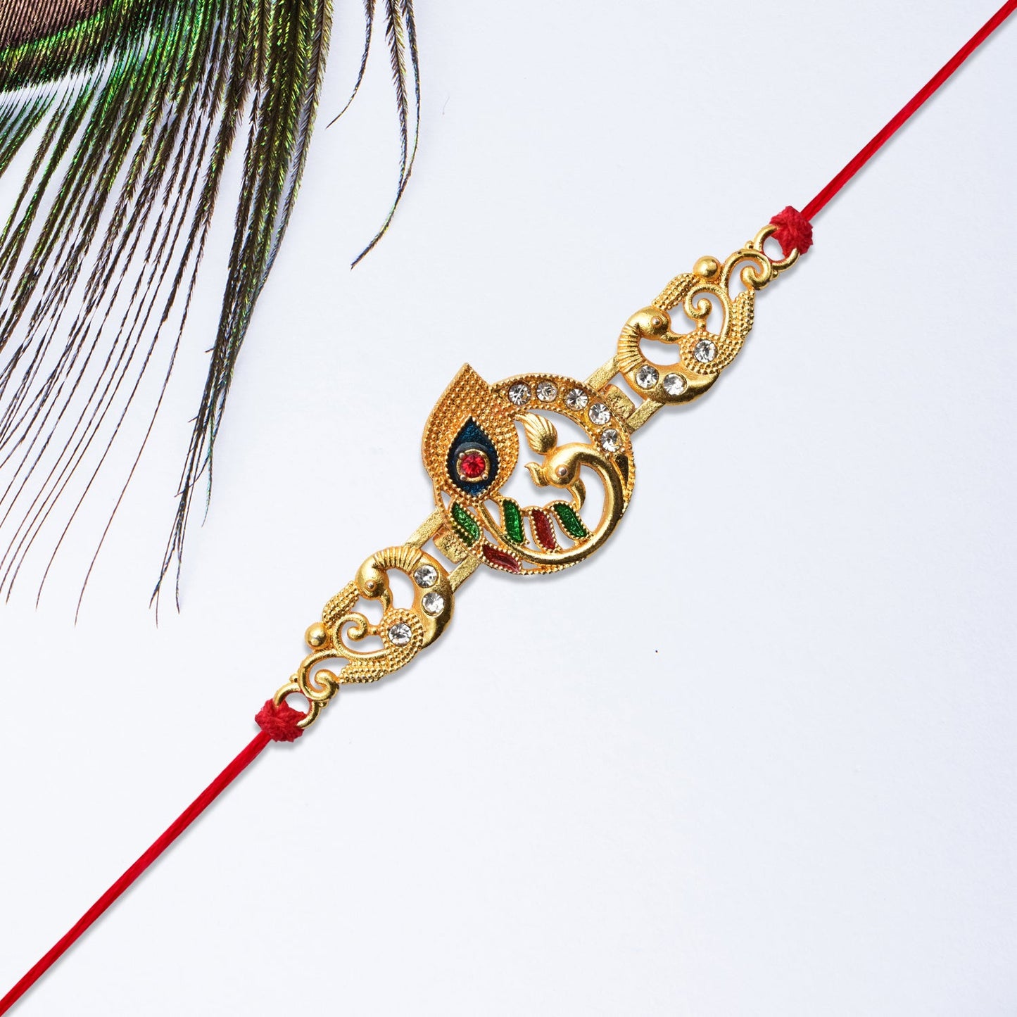 Golden Krishna Flute Rakhi with Colorful Enamel and Red Thread