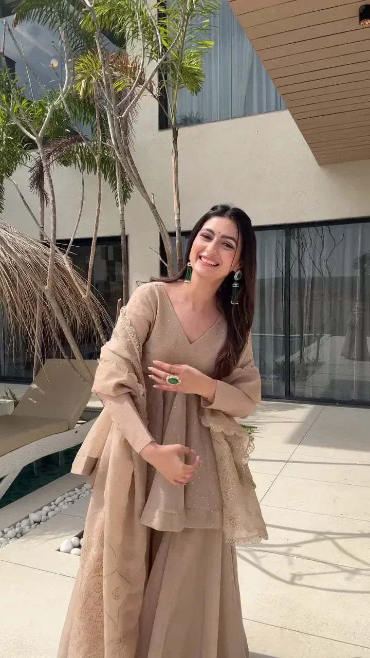 Beige Peplum Style Anarkali Dress with Flared Pants – Featuring Intricate Embroidery and a Sheer Dupatta with Scalloped Edges, Perfect for Weddings