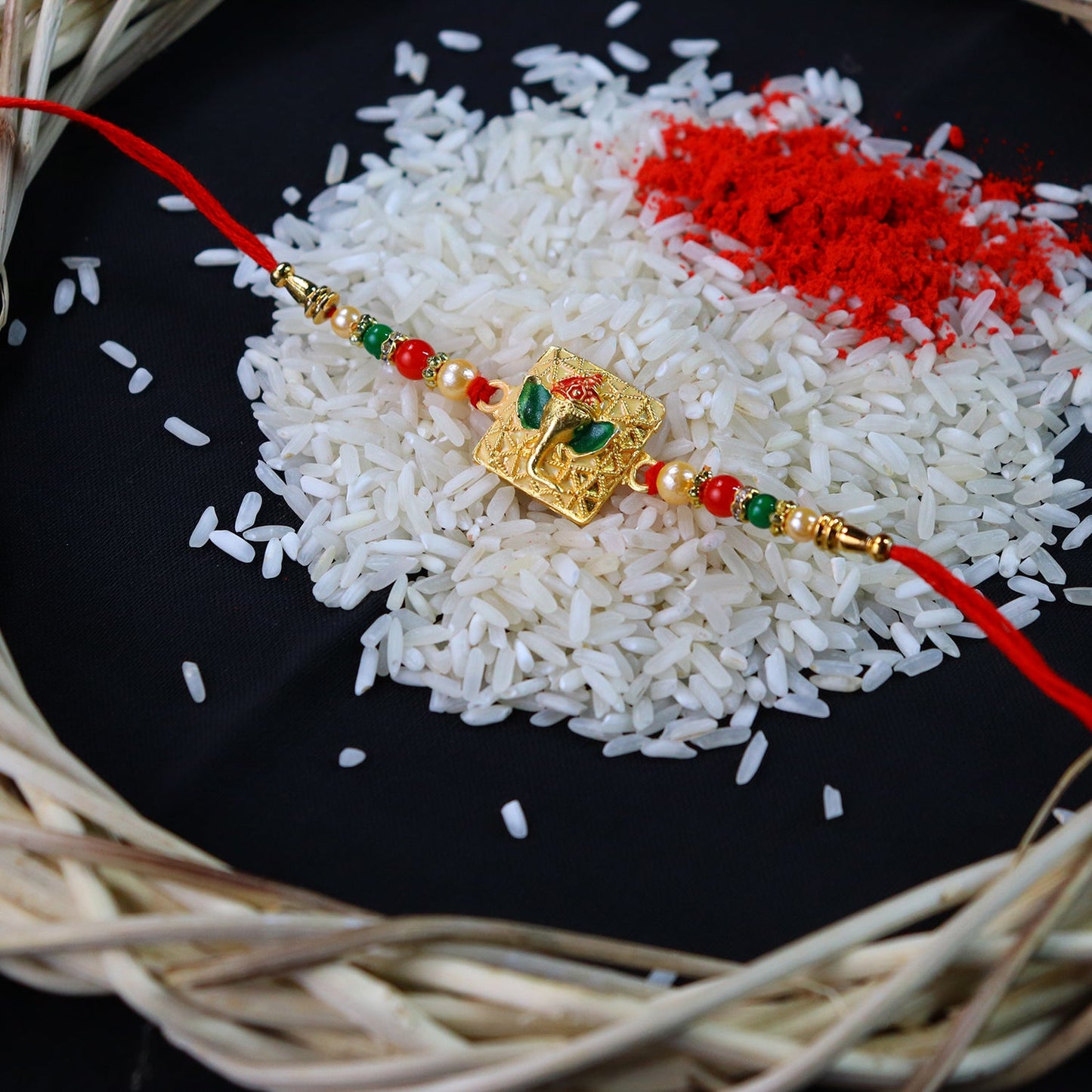 Golden Ganpati Rakhi with Red-Green Beads and Enamel Detailing