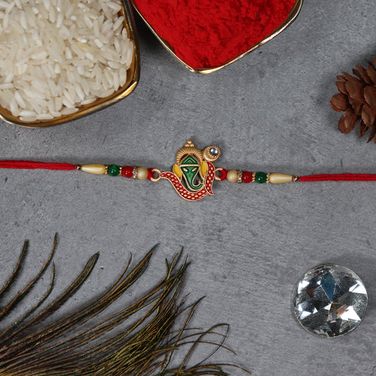 Green Enamel Lord Ganesha Rakhi with Decorative Red Thread and Golden Accents