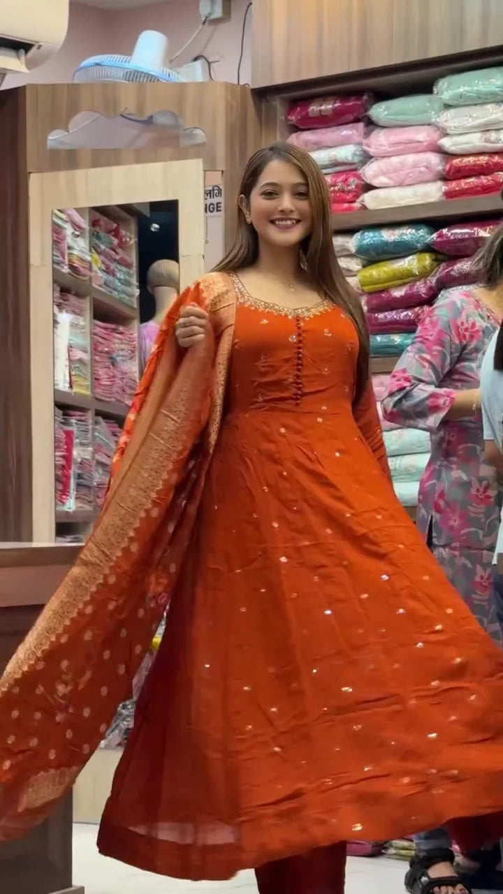 Burnt Orange Anarkali Gown with Intricate Neckline Embroidery and Floral Banarasi Dupatta, an Orange Tie-Dye Straight Kurta Set with White Threadwork
