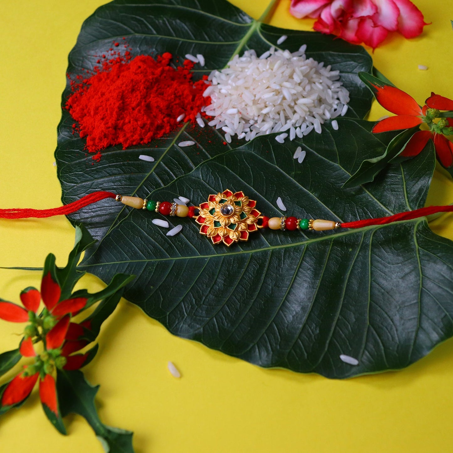 Designer Floral Rakhi with Beaded Strap – Red, Green & Gold Accents