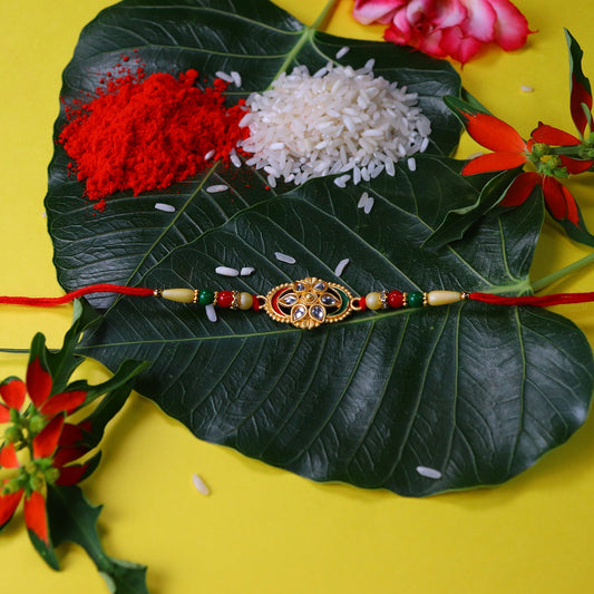 Traditional Oval Rakhi with Kundan Work and Red-Green Beads