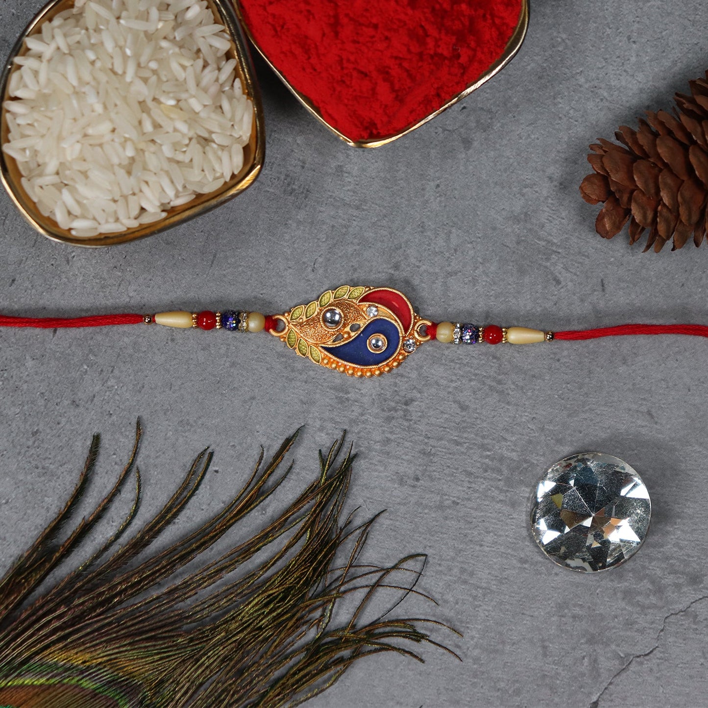 Elegant Rakhi with Enamel Paisley Design and Gold-Tone Embellishments