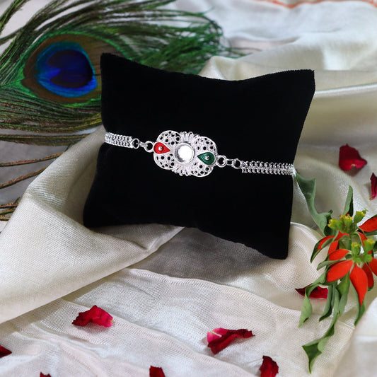 Elegant Silver Rakhi with Red-Green Enamel Accents and Central Mirror Stone