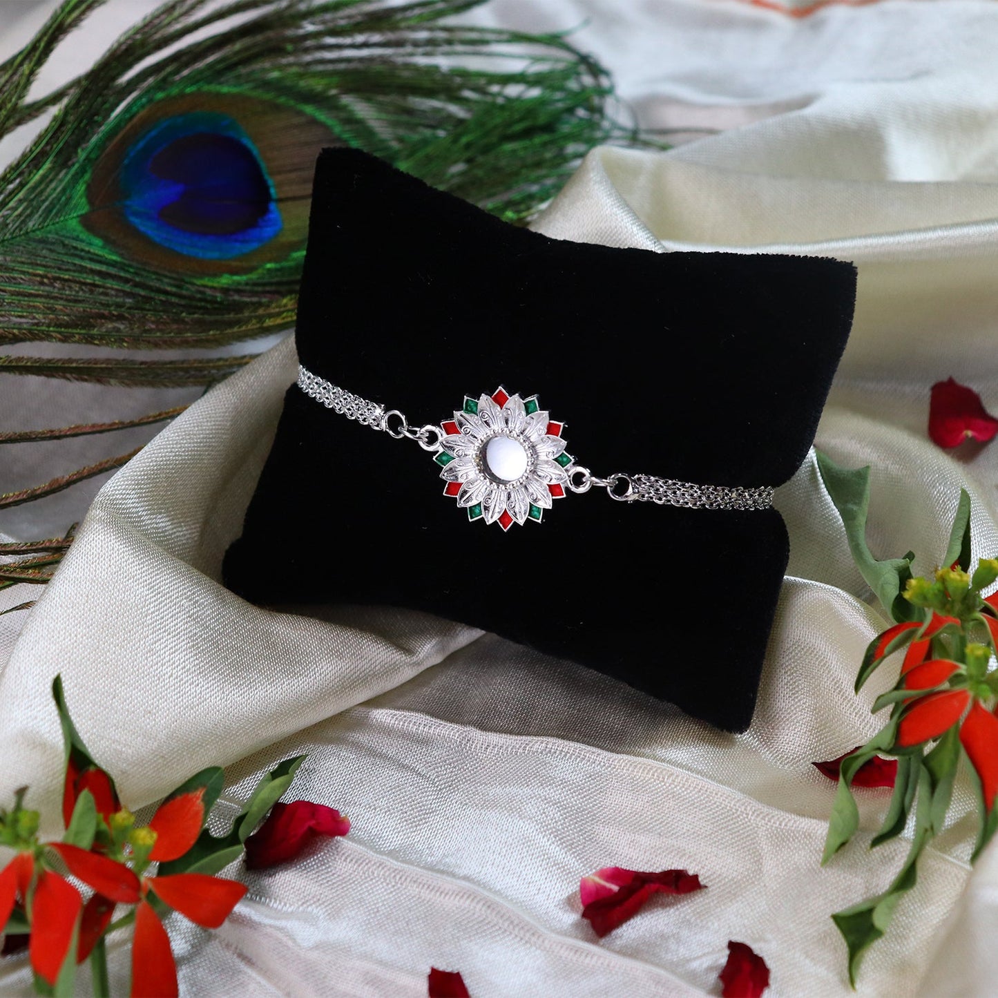 Elegant Silver-Plated Floral Rakhi with Red and Green Meenakari Accents