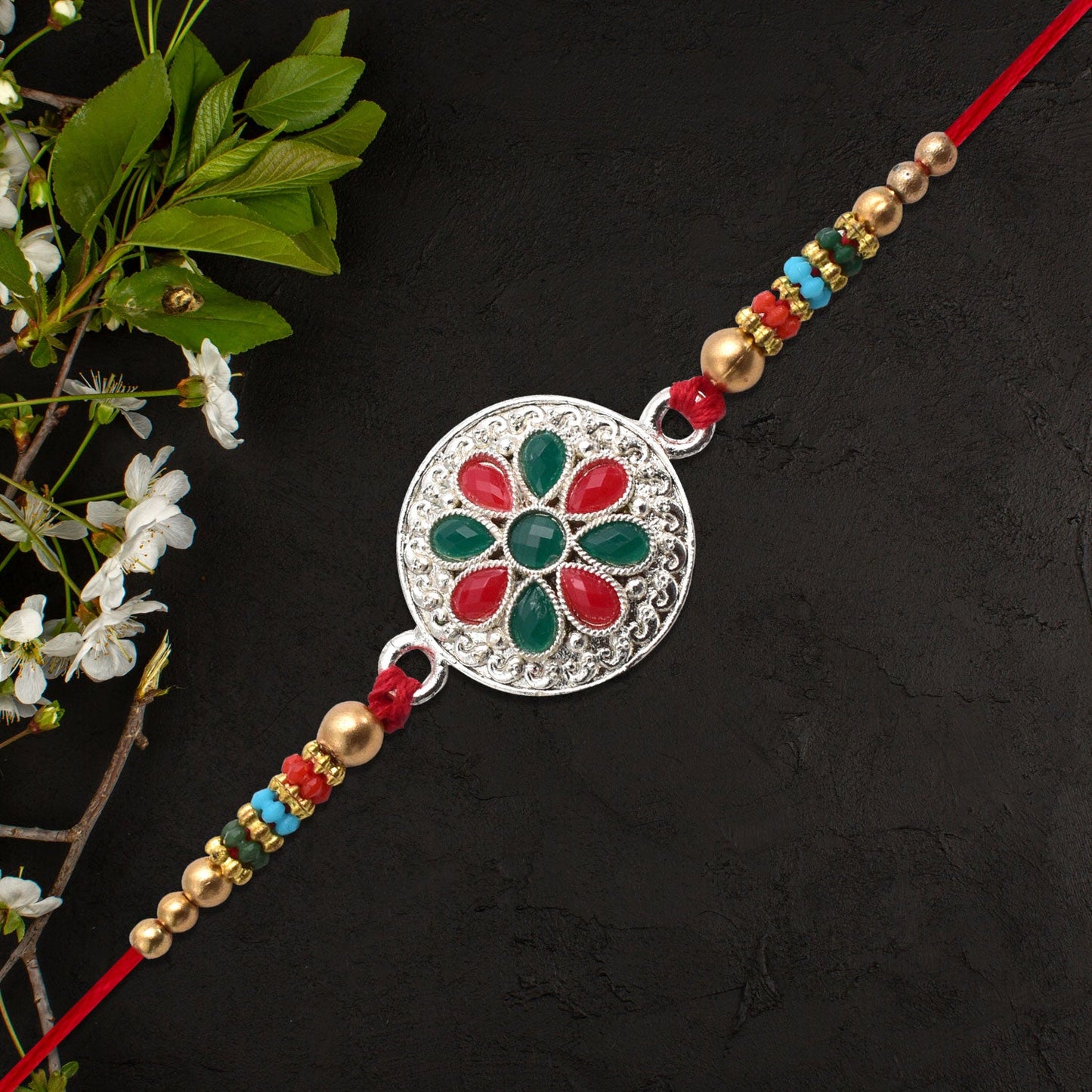Silver Plated Floral Rakhi with Red & Green Stones