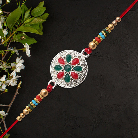 Silver Plated Floral Rakhi with Red & Green Stones