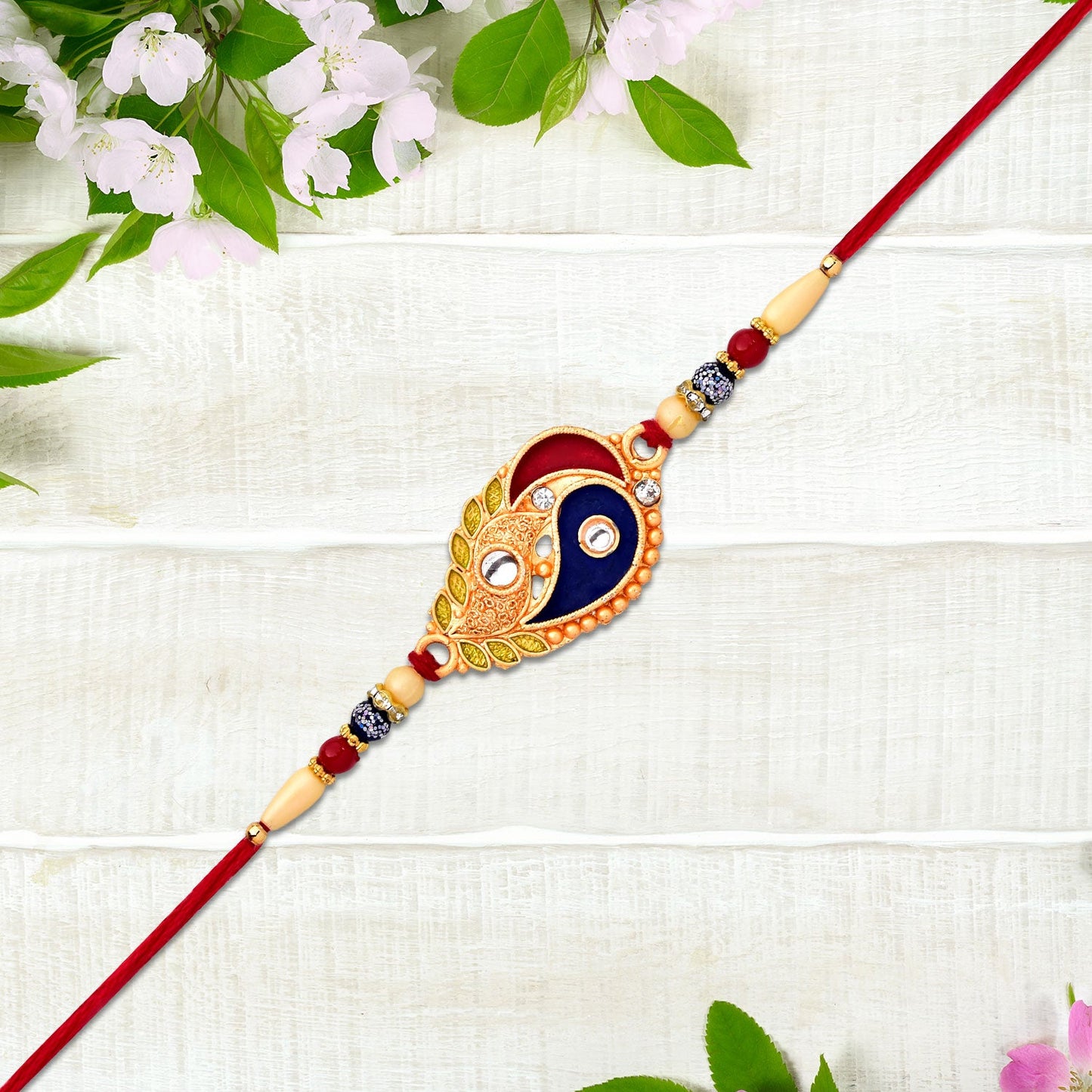 Elegant Rakhi with Enamel Paisley Design and Gold-Tone Embellishments