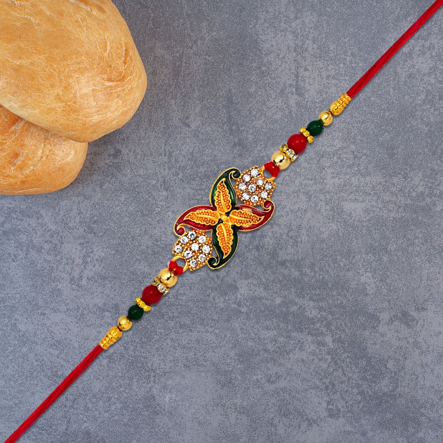 Elegant Red-Green Bead Rakhi with Intricate Golden Flower Motif