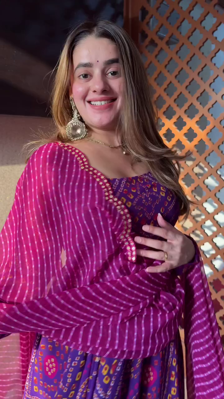 Such a vibrant and cheerful outfit! The purple hues with the intricate prints look so lively, and the flow of the dress is perfect for twirling