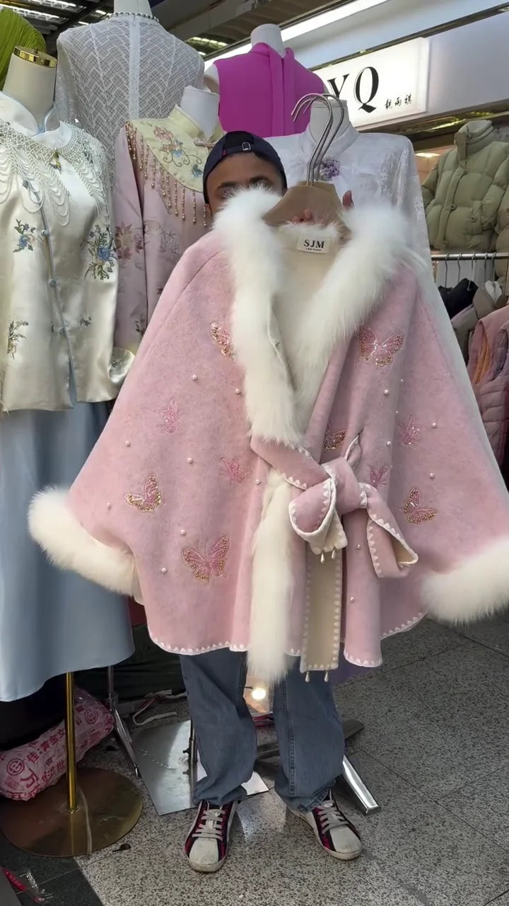 Luxurious Wool Blend Cape Coat with Plush Faux Fur Trimmed Collar and Hem, Featuring Delicate Embroidered Butterfly Appliqués, Faux Pearl Accents, and a Matching Self-Tie Waist Bow, Available in Elegant White and Soft Pink
